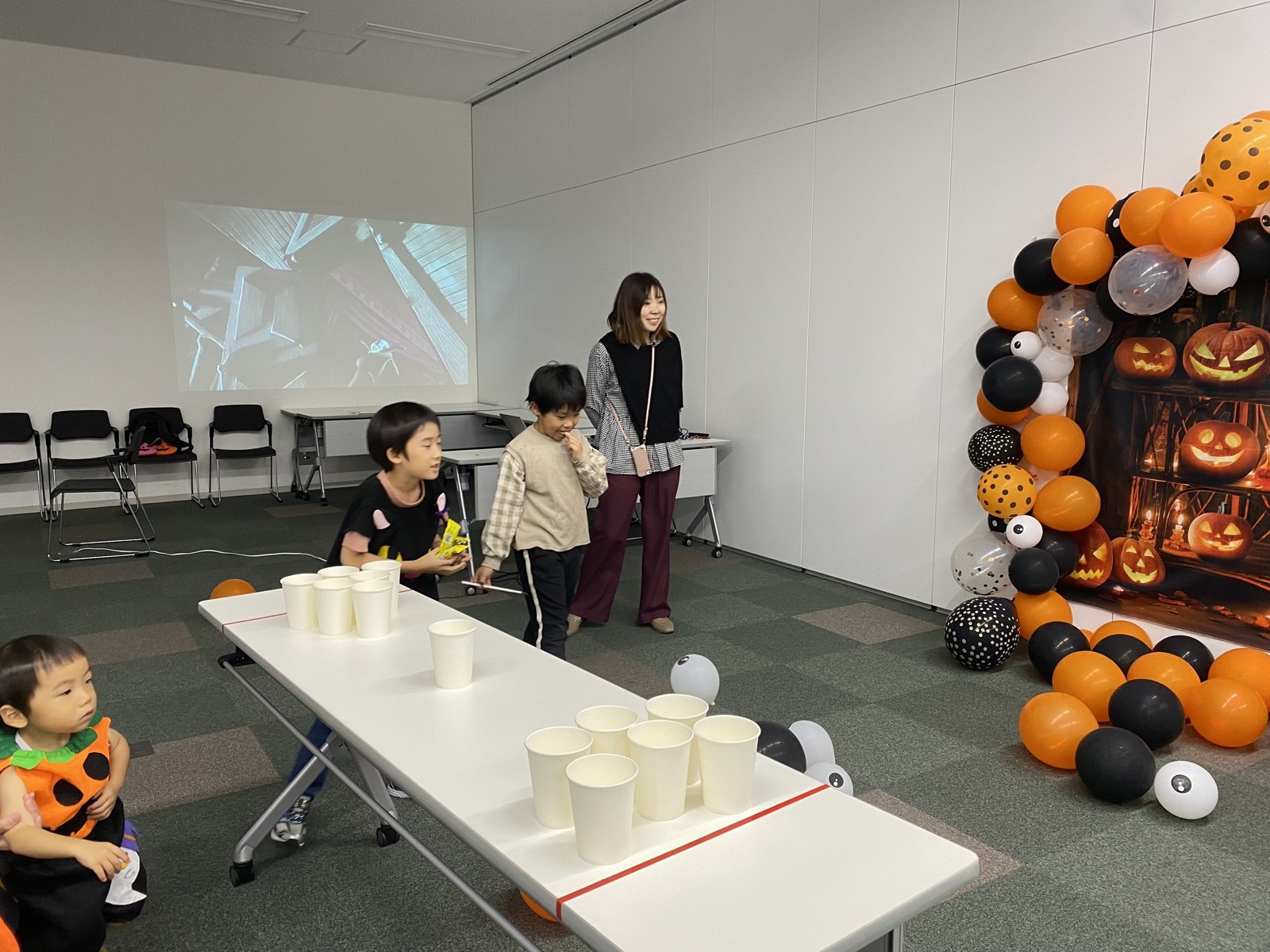 ハロウィン装飾の前でゲームを楽しむ子どもたち